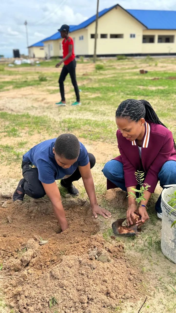 Lidya John and a students planting a tree